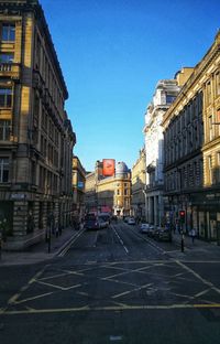 City street and buildings against blue sky