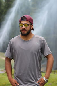 Portrait of young man wearing sunglasses standing outdoors