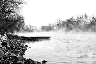 Boat moored at riverbank against sky