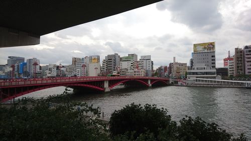 Bridge over river against cloudy sky