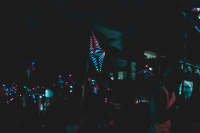 Man with illuminated star shape christmas lightings at night