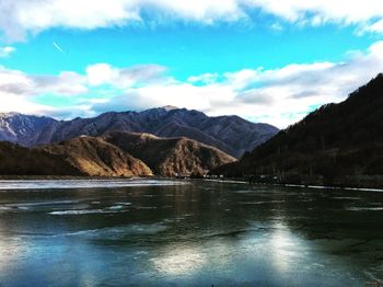 Scenic view of lake and mountains against sky