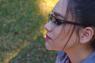 Close-up of young woman wearing eyeglasses at park