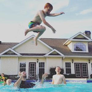 Full length of boy jumping into swimming pool