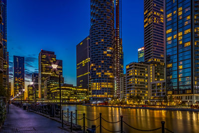 Illuminated buildings against sky at dusk