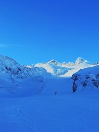 Scenic view of snowcapped mountains against clear blue sky