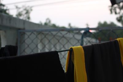 Close-up of clothes drying against fence