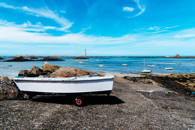 Boat out of water in the pier against bay with lighthouse a sunny day of summer. ile vierge, brittan