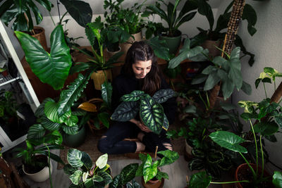 Portrait of young woman standing amidst plants