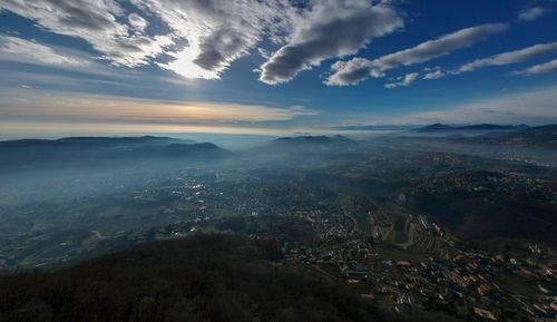 Aerial view of landscape and sea against sky during sunset