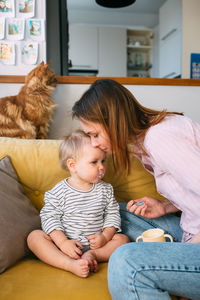 Mom feeds a small child at home with yogurt from a spoon. family concept