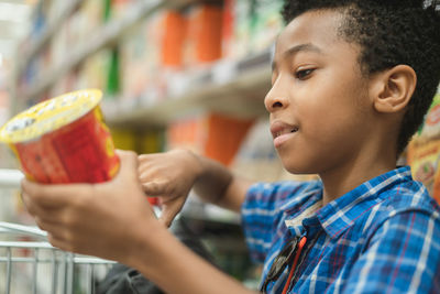 Side view of boy shopping in supermarket