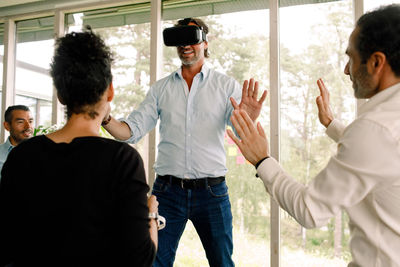 Businessman gesturing while wearing virtual reality simulator at convention center