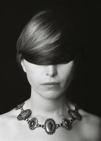 Close-up portrait of a young woman over black background