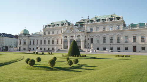 Lawn in front of building against clear sky