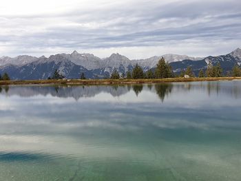 Scenic view of lake by mountains against sky