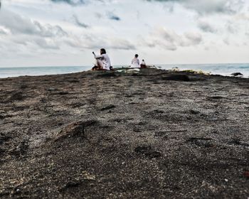 People on beach against sky