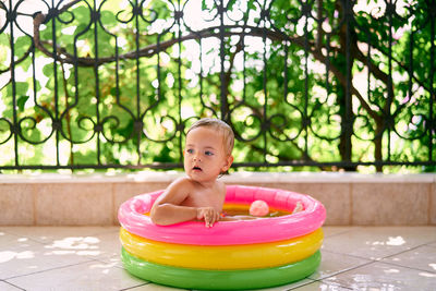 Portrait of boy sitting in swimming pool