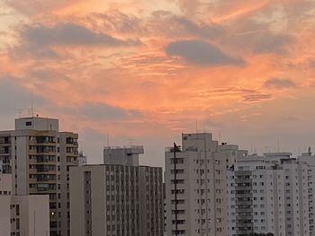 Buildings in city against sky during sunset