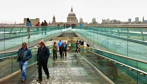 People walking on bridge in city