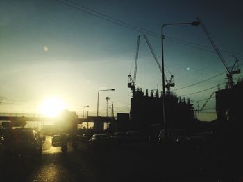 Cars on road against sky at sunset