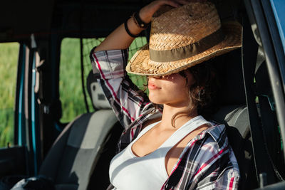 Young woman wearing hat sitting in car