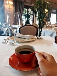 Midsection of coffee cup on table at restaurant