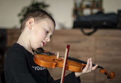 Boy playing violin at home