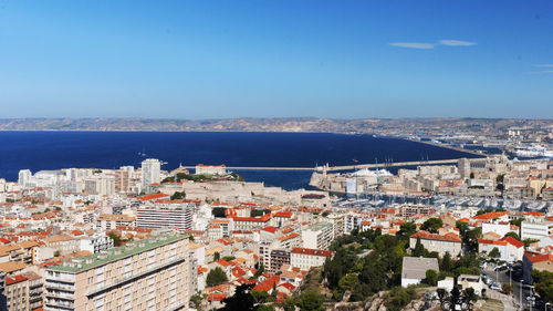 High angle view of townscape by sea against sky