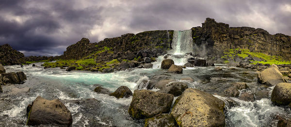 Scenic view of waterfall against sky