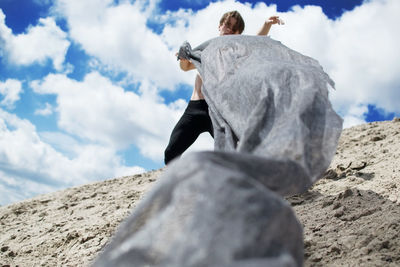 Low angle view of man holding textile