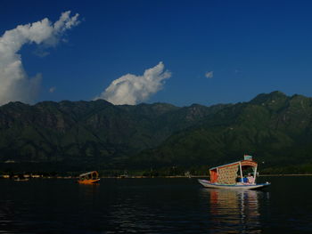 Boat sailing on sea against blue sky