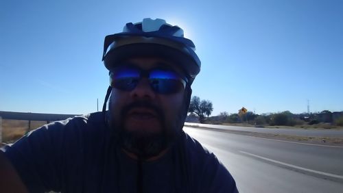 Portrait of man wearing sunglasses against clear blue sky