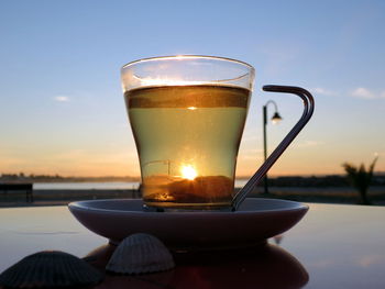 Close-up of tea served on table during sunset