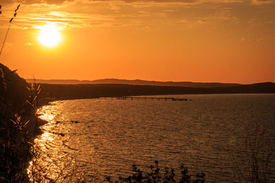 Scenic view of sea against orange sky