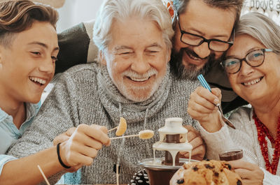 Portrait of smiling friends toasting drinks at home