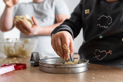 Father feeling playful with his caucasian little daughter, while preparing homemade dough 