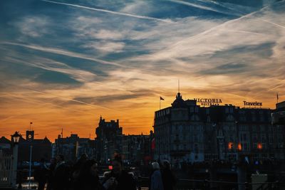 Exterior of buildings in city against sky at sunset