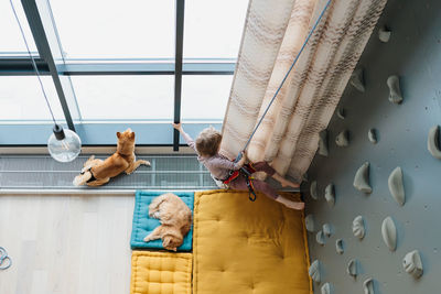 Young boy indoor rock climbing with his father instructor. hobby or home sport 