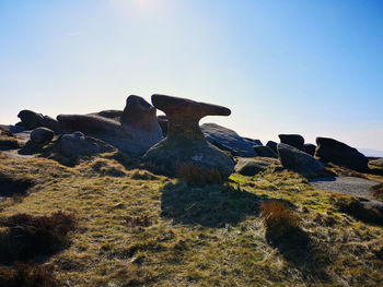 Rocks on field against clear sky