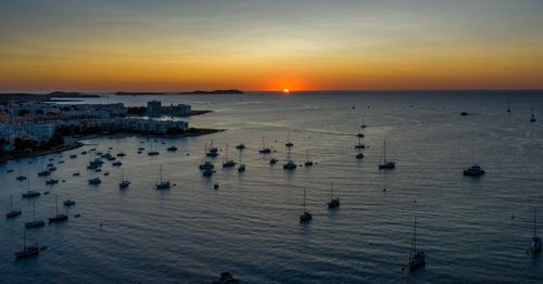 High angle view of city at waterfront during sunset