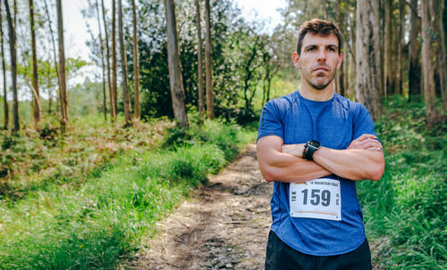 Man standing with marathon bib in forest