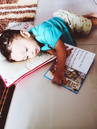 High angle view of cute girl lying on book