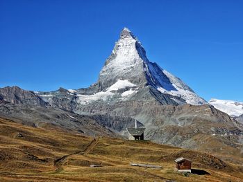 Built structure on snowcapped mountain against sky