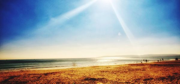 Scenic view of beach against sky on sunny day