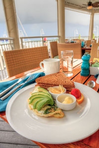 Egg white omelet with spinach, avocado slices and cheese along with wheat toast for breakfast