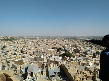 Aerial view of townscape by sea against clear sky