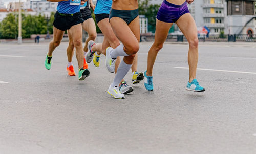 Legs runners athletes women and men run city marathon