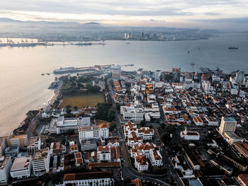 High angle view of buildings by sea against sky