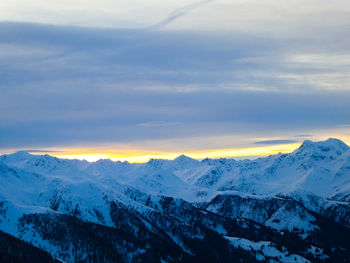 Scenic view of snowcapped mountains against sky during sunset